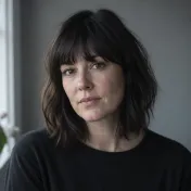 Portrait of a woman with dark shoulder-length hair and a fringe